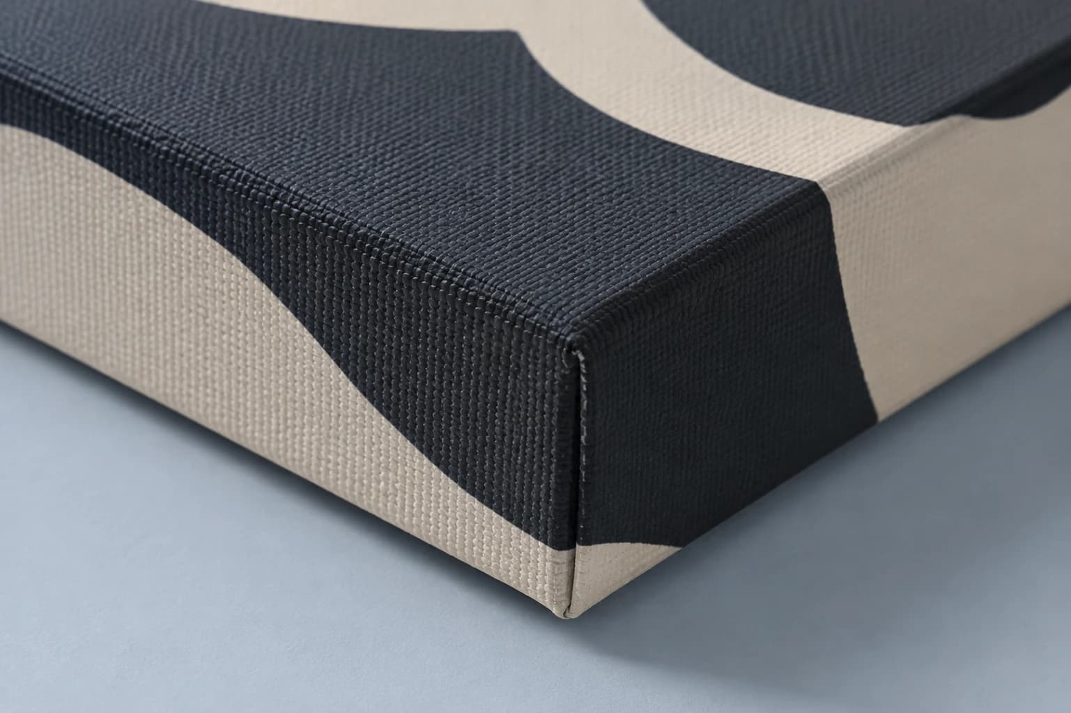 Close-up of fine matte canvas weave and a precisely wrapped black and ivory printed corner